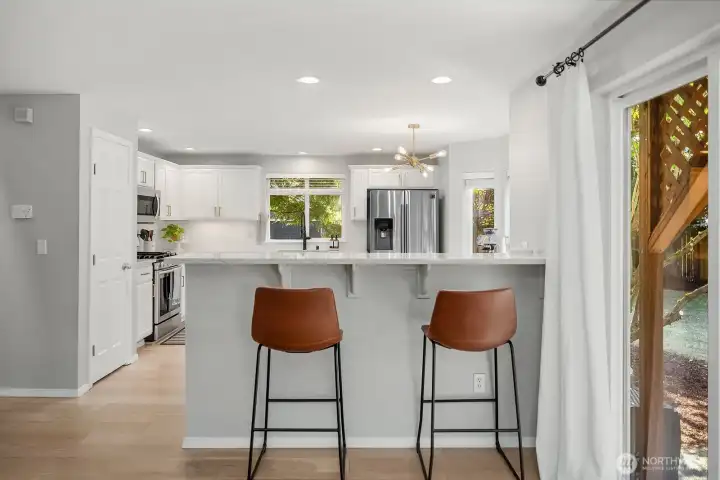 Updated kitchen with modern finishes, quartz counters, breakfast bar and a pantry