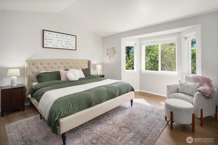 Primary bedroom has vaulted ceiling, bay window with natural light and views of the backyard