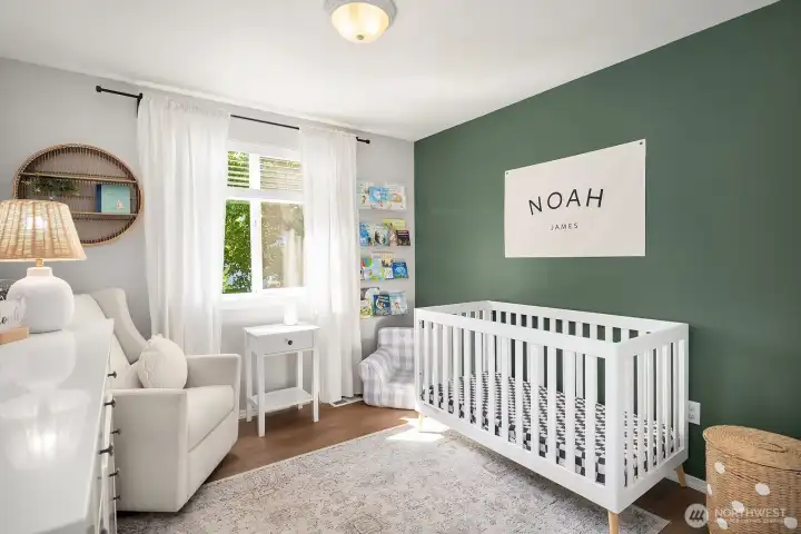 2nd bedroom with faux wood blinds, a deep green wall focal point and views of the backyard.