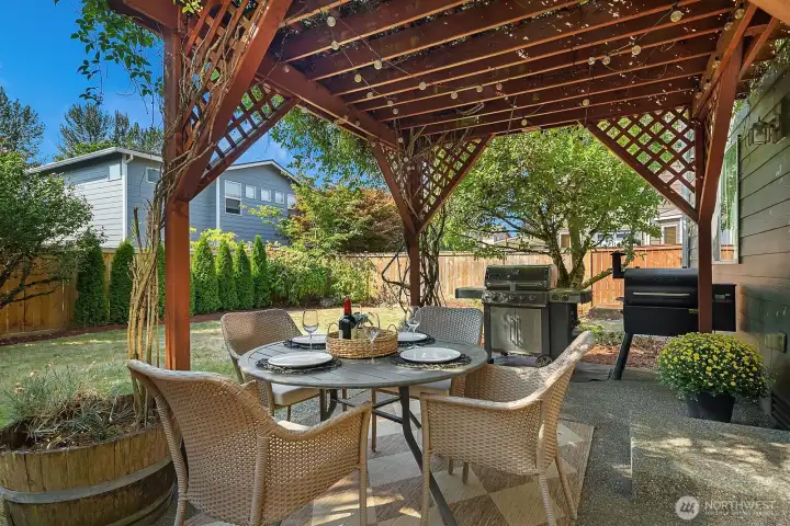 The mature landscaping features a beautiful trellis over the rear patio for entertaining at home.