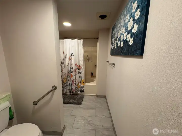 Primary bathroom lavatory & tub/shower both with safety rails in place