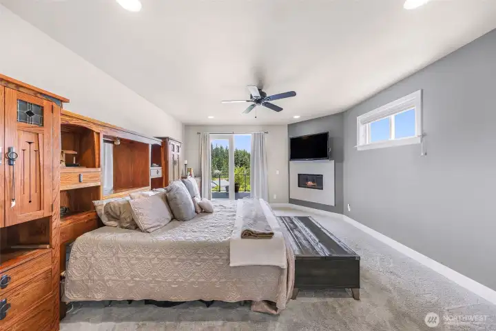 Primary bedroom with fireplace and french doors to the deck