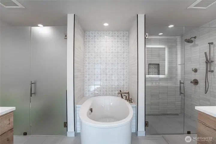 Modern jetted self-cleaning soaking tub is the focal point of the en suite primary bathroom.