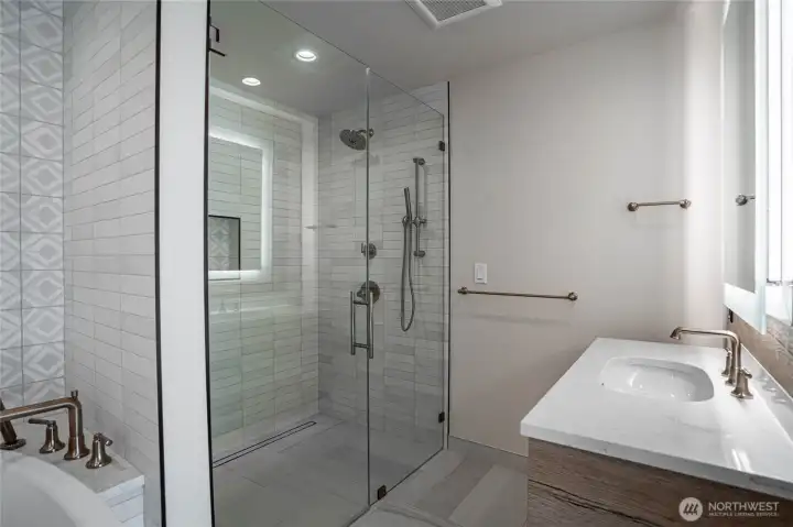 Oversized shower with massage fixtures and beautiful tile work.