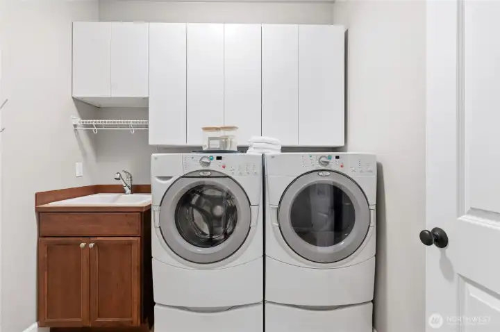 Main level laundry room with utility sink.