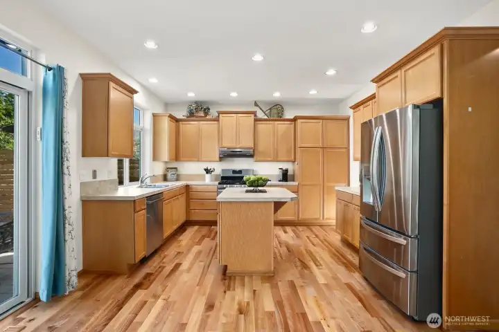 Kitchen with beautifully refinished solid hardwood floors & SS appliances.