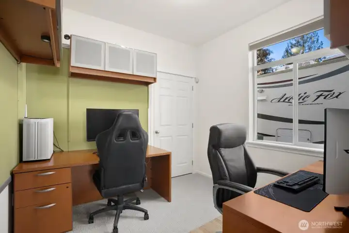 Office / 6th bedroom (main level).  Both desks, attached cabinets, and wall boards (green cloth) convey with sale.