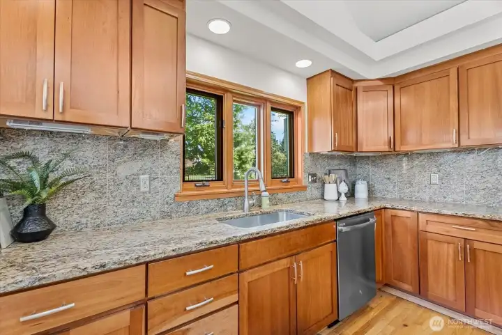 Granite goes up the wall for a full backsplash and under the cabinet lighting