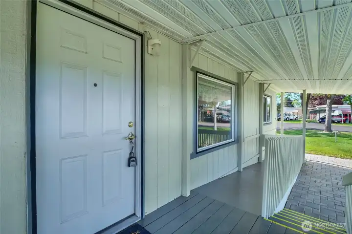 Take your pick between coming up the gently sloping ramp or the steps, safety-painted with yellow stripes on the edge to this wonderful covered front patio.