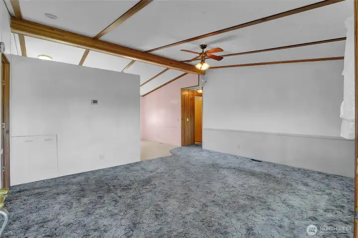 Coming through the front door you'll see the living room. Wondering what the square is on the left wall?  That's ingenuity! The seller was handy and created storage there, located under the kitchen corner countertop on the other side.  Just pull it open from here.