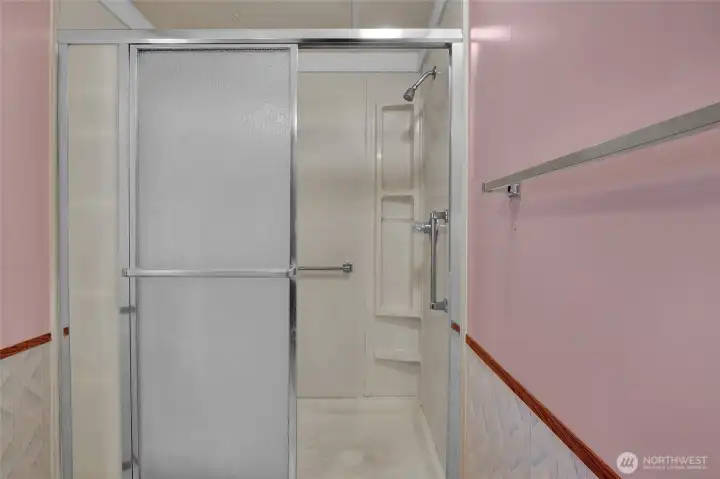 Full size shower with plenty of space to put your shampoos, conditioners and soaps.  Those grab bars are handy too!