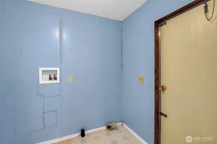 Here we are in the utility room where there are hookups for a washer and dryer.  The door leads outside to the new steps and the garden area.