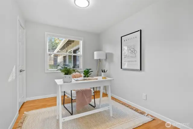 The first of three bedrooms, currently set up as a functional office space, features a convenient closet in the corner for added storage.