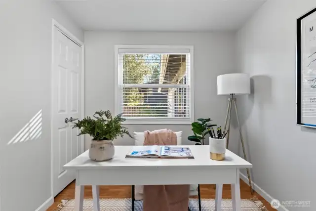 The first of three bedrooms, currently set up as a functional office space, features a convenient closet in the corner for added storage.