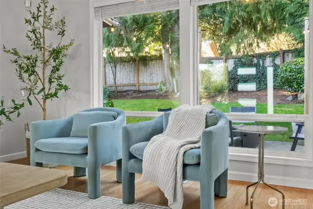 Expansive windows offer a seamless connection to the backyard, while lush trees provide a natural sense of privacy.