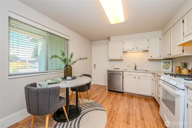 The bright, cheery Kitchen features laminate wood floors, abundant cabinetry and newer appliances.  Notice the gas range! The door ahead opens to the one-car Garage AND washer & dryer.