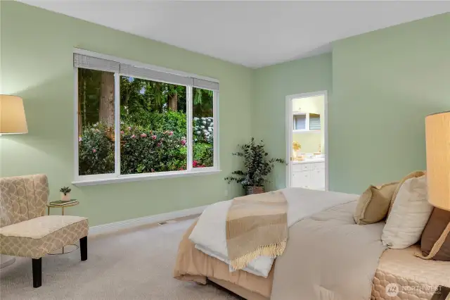 Hard-to-find Primary ensuite bedroom on main level. Paneled Quaker door to south-facing ensuite. Large picture window with window screens, two-inch blinds, with outlook to extremely-private back yard setting. Paneled Quaker pocket door to Primary bath.