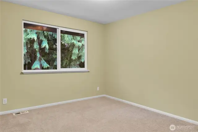 West bedroom. Paneled Quaker door. New carpet. Closet with raised-panel bi-fold Quaker-style doors. South-facing window with window screen overlooks Park and water feature below.
