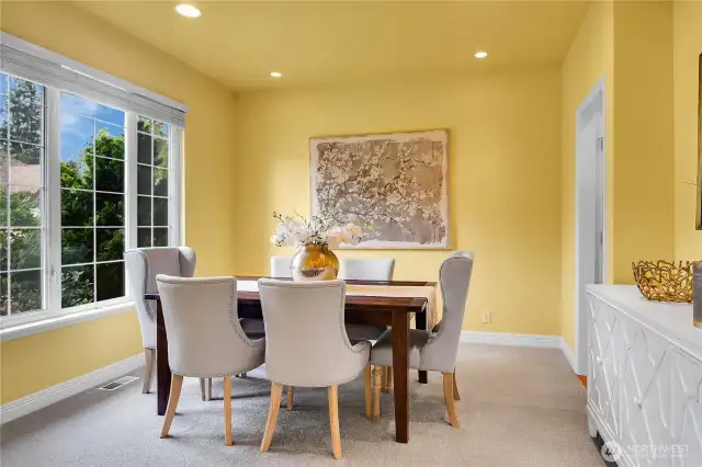 Dining room across from Living room. Added adjustable accent lighting at buffet alcove and east side of dining area.. Signature William Buchan millwork. Traditional divided-light windows with window screens and two-inch blinds. High ceiling with recessed lighting. Doorway to kitchen.