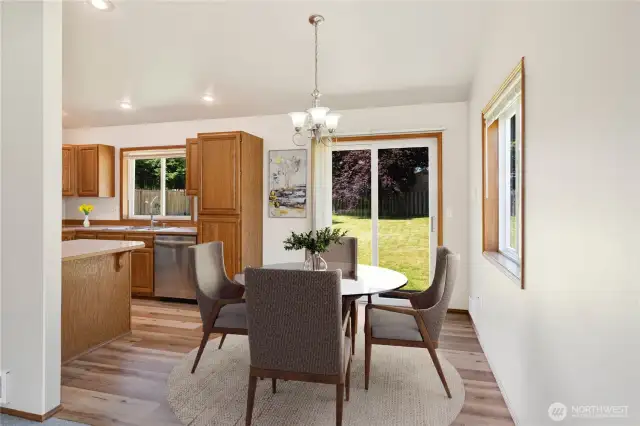 Bright Dining Room with Sliding Glass Doors to the Backyard, Featuring New Lifetime-Guaranteed Flooring in Both Dining and Kitchen Areas – Seamless Indoor-Outdoor Living!  Photo is virtually staged.