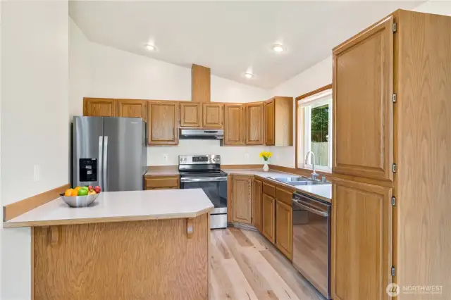 Well laid out Kitchen Featuring Stainless Steel Appliances, New Flooring & a Convenient Breakfast Bar – Perfect for Casual Dining!  Photo is virtually staged.
