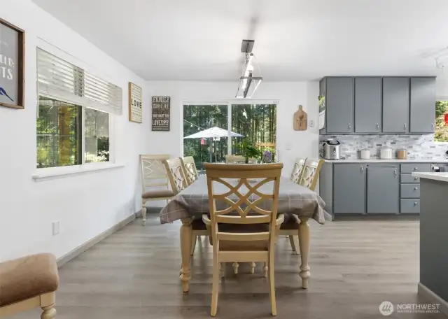 The dining area connects seamlessly to both the kitchen and living room, with a sliding door that invites the outdoors in.