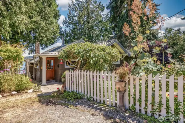 Full of storybook charm, framed by a classic white picket fence that adds warmth and lovely curb appeal.