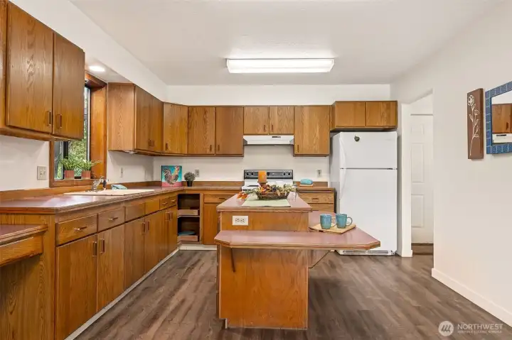 Hold your holiday buffet or spread out your favorite project on this generous island smartly placed for useful kitchen use, or easy passage to the back entry and utility space in the rear of the home.