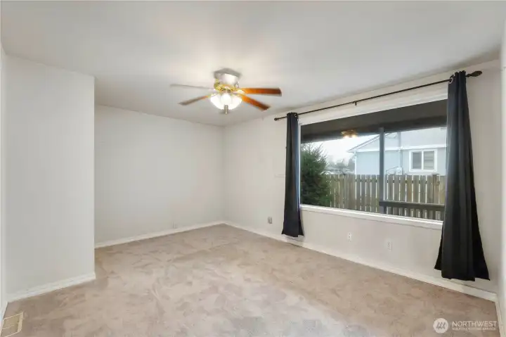 Freshly carpeted Family room with fan and large window looking out to another covered area outside