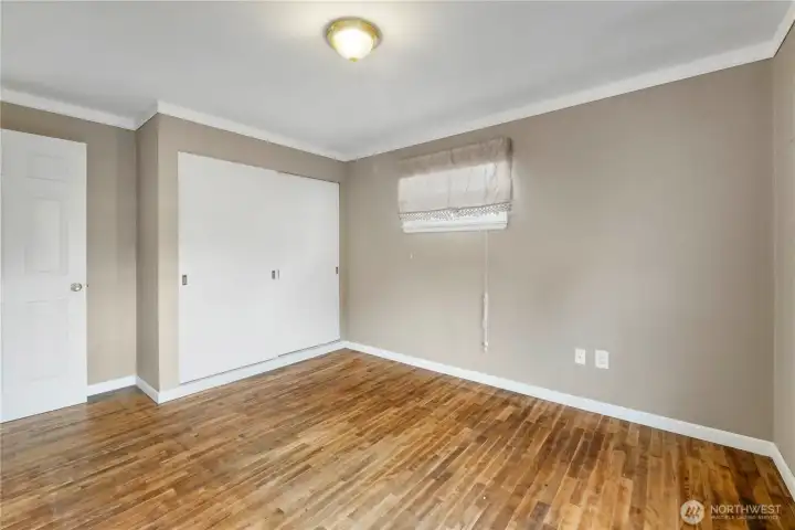 2nd Bedroom showing off the sliding wood doors of the closet... Primary bedroom has 3 doors for it's closet