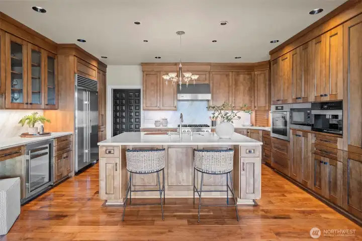 Where form meets function. Warm wood tones flow seamlessly from the cabinetry to the walnut flooring, creating a grounded, high-end atmosphere for the modern chef.