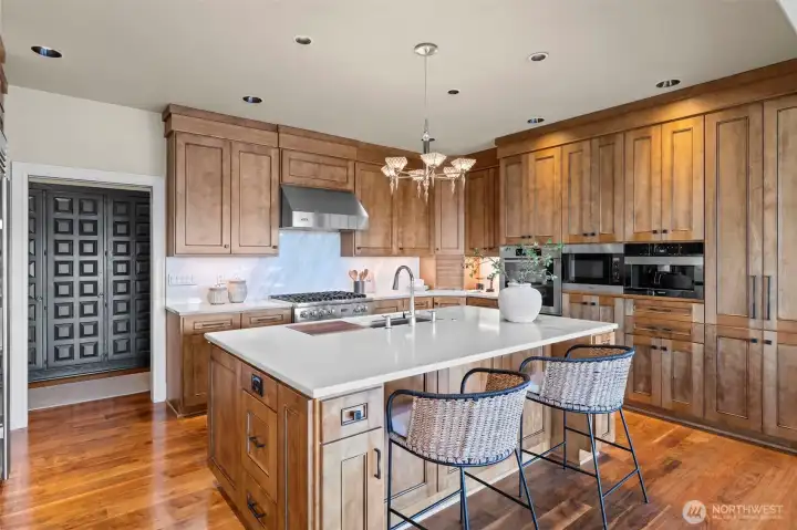 Texture and tone in perfect harmony. The dramatic sweep of the marble range backsplash brings a cool, sculptural element to the kitchen’s warm wood-on-wood aesthetic.