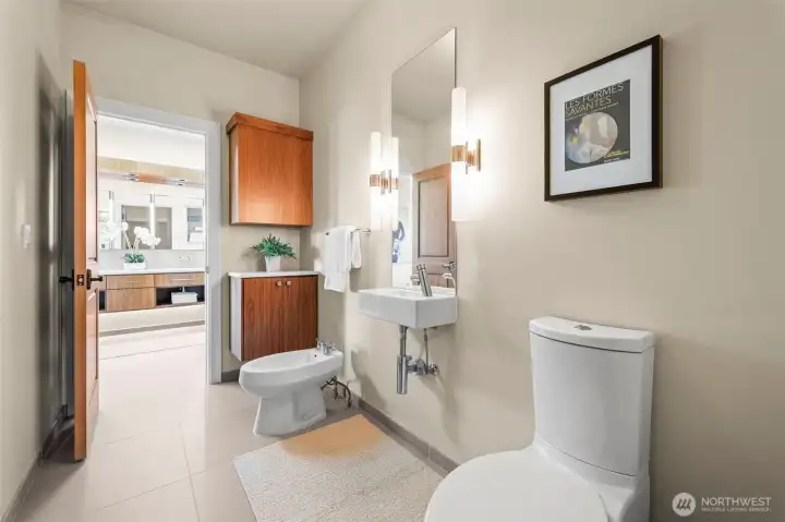 Continuing the home's theme of uncompromising luxury, this private water closet offers a refined sanctuary featuring a premium bidet and a dedicated vanity for added convenience.