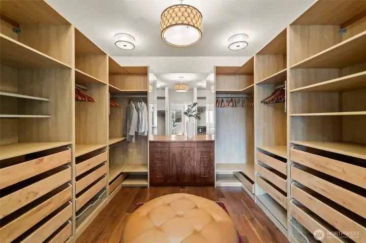 More than a closet, this space is a private gallery for your wardrobe. The expansive built-in storage system offers effortless organization, while designer light fixtures cast a sophisticated glow over the artisanal woodwork.