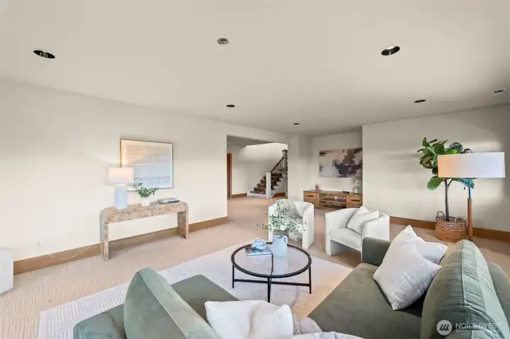This massive lower-level bonus room serves as the ultimate media center, game room, or secondary social hub, maintaining the home’s hallmark of architectural volume.