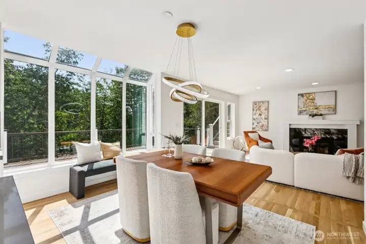 Walls of windows fill the dining and living areas with natural light and wooded views.