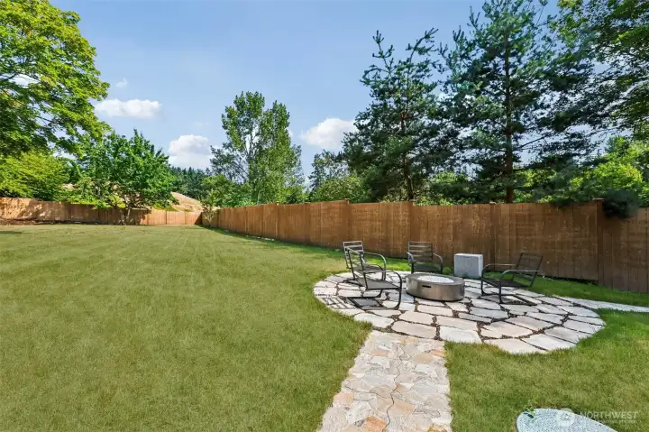 The expansive, partially fenced yard offers plenty of room to play, garden and entertain. Fire pit is piped for gas.