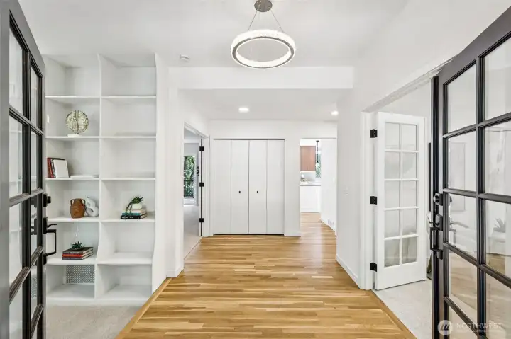 The welcoming entry features hardwood floors, built-in shelving and stylish French doors.