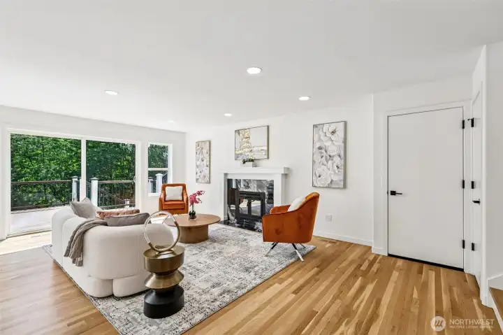The bright living room opens to the deck and centers around a striking gas fireplace.