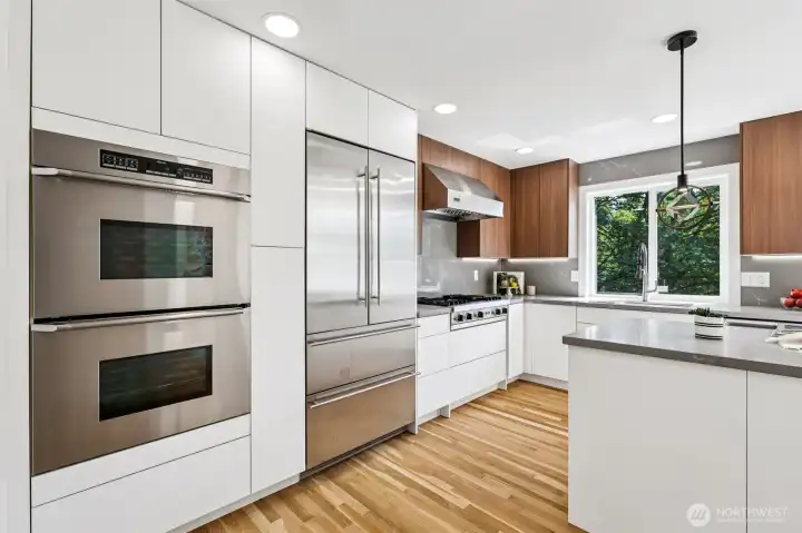 A full appliance wall includes double ovens, an oversized refrigerator and abundant cabinetry.
