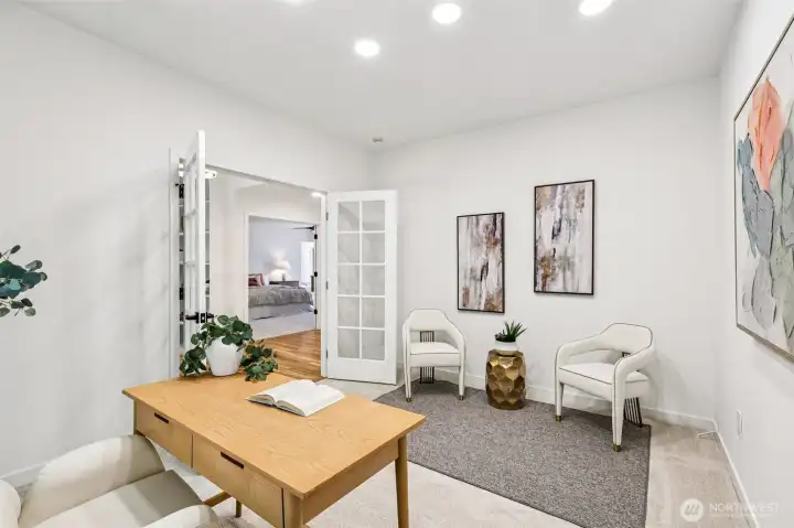 The spacious main-floor office includes room for a desk, seating area and additional furnishings.