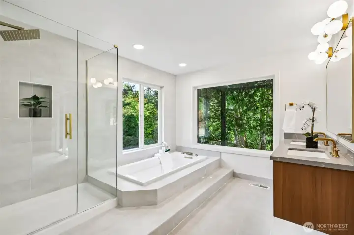 The remodeled primary bath features an oversized soaking tub and a large glass-enclosed shower and heated floors.