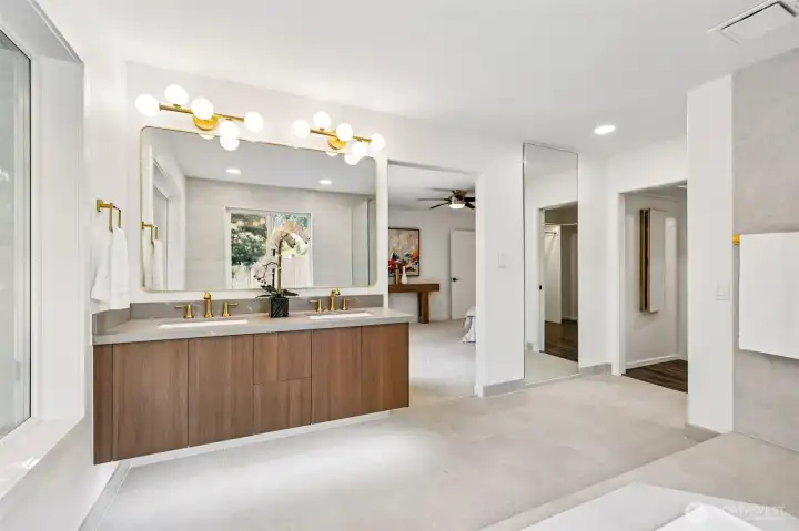 Dual sinks, warm cabinetry and updated finishes create a bright, spa-inspired retreat.