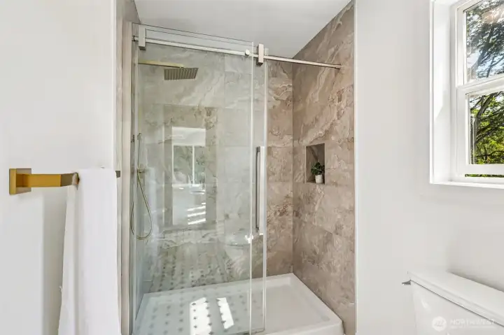 A beautifully tiled shower completes the updated Jack-and-Jill bathroom.