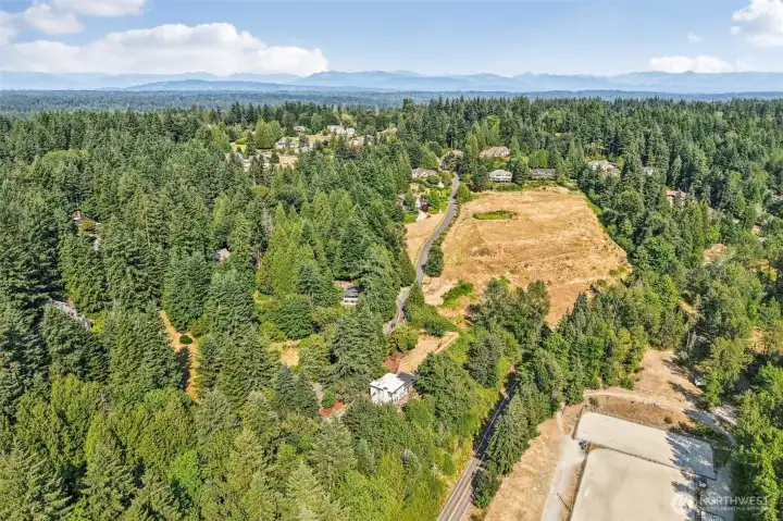 Westerly aerial views stretch across the surrounding evergreens toward the Olympic Mountains.