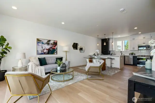 Spacious living area with 9ft ceilings and large windows, perfect for gathering with loved ones and enjoying natural light. Open layout seamlessly connects to the kitchen, creating an inviting and versatile living space.