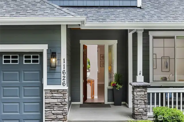 The front entry is welcoming with a porch area and fresh stone work.