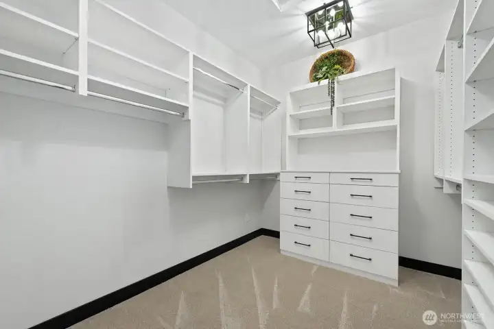 One of two large walk-in closets with custom cabinetry.