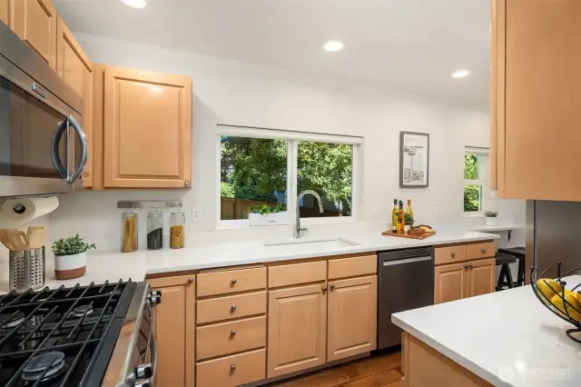 Convenient kitchen has gas stove, quartz counters, stainless steel appliances and walk-in pantry.