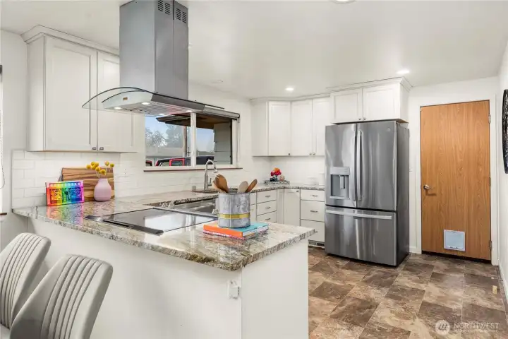 Beautifully remodeled kitchen boasts stianless steel appliances (all stay!) and modern white cabinetry.